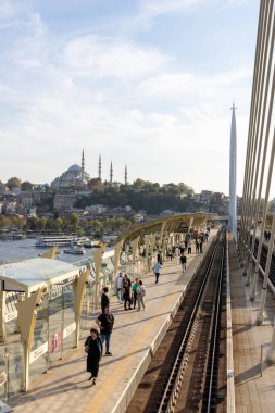 İstanbul Türkiye 24 Eylül 2024, Tramvay ve Golden Horn Metro Köprüsü 'ndeki insanlar. En kalabalıklardan biri olan Halic Tren İstasyonu 'nun manzarası Altın Boynuz' un üzerinde köprü istasyonu olarak yer almaktadır.. 