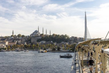 İstanbul Türkiye 24 Eylül 2024, Tramvay ve Golden Horn Metro Köprüsü 'ndeki insanlar. En kalabalıklardan biri olan Halic Tren İstasyonu 'nun manzarası Altın Boynuz' un üzerinde köprü istasyonu olarak yer almaktadır.. 