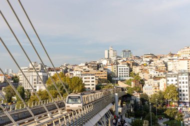 İstanbul Türkiye 24 Eylül 2024, Tramvay ve Golden Horn Metro Köprüsü 'ndeki insanlar. En kalabalıklardan biri olan Halic Tren İstasyonu 'nun manzarası Altın Boynuz' un üzerinde köprü istasyonu olarak yer almaktadır.. 