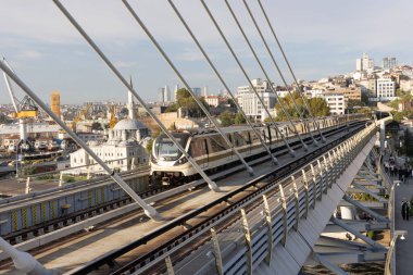 İstanbul Türkiye 24 Eylül 2024, Tramvay ve Golden Horn Metro Köprüsü 'ndeki insanlar. En kalabalıklardan biri olan Halic Tren İstasyonu 'nun manzarası Altın Boynuz' un üzerinde köprü istasyonu olarak yer almaktadır.. 