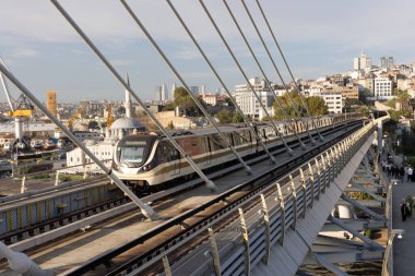 İstanbul Türkiye 24 Eylül 2024, Tramvay ve Golden Horn Metro Köprüsü 'ndeki insanlar. En kalabalıklardan biri olan Halic Tren İstasyonu 'nun manzarası Altın Boynuz' un üzerinde köprü istasyonu olarak yer almaktadır.. 