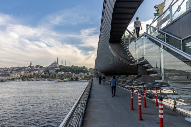 İstanbul Türkiye 24 Eylül 2024, Tramvay ve Golden Horn Metro Köprüsü 'ndeki insanlar. En kalabalıklardan biri olan Halic Tren İstasyonu 'nun manzarası Altın Boynuz' un üzerinde köprü istasyonu olarak yer almaktadır.. 