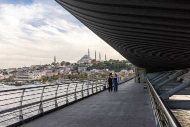 İstanbul Türkiye 24 Eylül 2024, Tramvay ve Golden Horn Metro Köprüsü 'ndeki insanlar. En kalabalıklardan biri olan Halic Tren İstasyonu 'nun manzarası Altın Boynuz' un üzerinde köprü istasyonu olarak yer almaktadır.. 