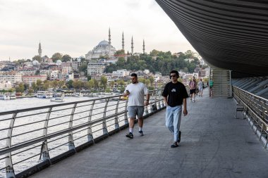 İstanbul Türkiye 24 Eylül 2024, Tramvay ve Golden Horn Metro Köprüsü 'ndeki insanlar. En kalabalıklardan biri olan Halic Tren İstasyonu 'nun manzarası Altın Boynuz' un üzerinde köprü istasyonu olarak yer almaktadır.. 