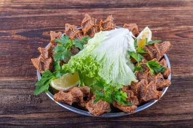 Sigara kofte veya ahşap arka planda çiğ köfte. Geleneksel lezzetli Türk yemekleri; Türkçe adı; Cig kofte (Türkçe çiğ köfte) marullu.