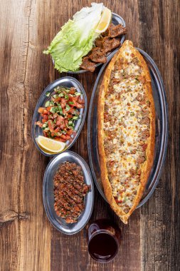 Geleneksel Türk yemeği olarak peynir etli Kusbasi pide pita. Türkçe adı: Kusbasili kasarli pide.