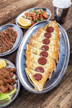 Pide, Türk teknesi sosisli (sucuk) ve baharatlı ve otlu düz ekmek şeklinde. Biberli ve peynirli Türk pide tabağı. Türkçe adı: Sucuklu pide.