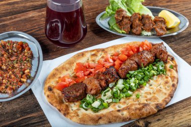 Geleneksel Türk mutfağı, lezzetli et sebzeli şiş kebap ve ahşap masada lavaş..