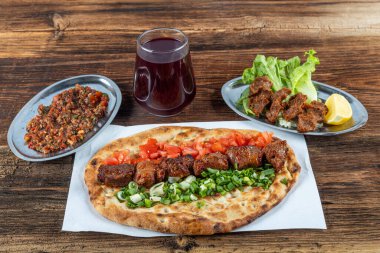Geleneksel Türk mutfağı, lezzetli et sebzeli şiş kebap ve ahşap masada lavaş..