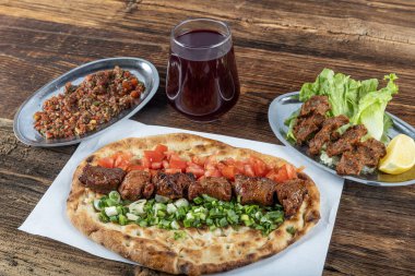 Geleneksel Türk mutfağı, lezzetli et sebzeli şiş kebap ve ahşap masada lavaş..