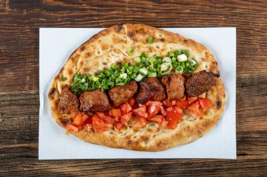 Geleneksel Türk mutfağı, lezzetli et sebzeli şiş kebap ve ahşap masada lavaş..