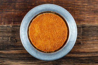 Orta Doğu tatlıları kunefe kunafa kadayif şam fıstıklı Türk geleneksel tatlısıyla Türk tatlısına pudra ve peynir şam fıstıklı kadaye servis edilirse tatlı kunafa veya konafa.