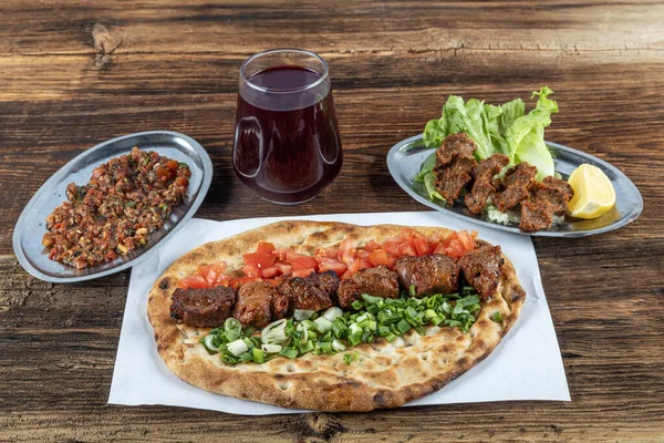 Geleneksel Türk mutfağı, lezzetli et sebzeli şiş kebap ve ahşap masada lavaş..