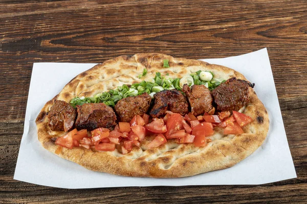 Geleneksel Türk mutfağı, lezzetli et sebzeli şiş kebap ve ahşap masada lavaş..