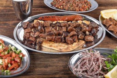 Turkish cuisine Liver shish portion. Famous Urfa meat liver, ciger wrapped by lavash with roasted chili pepper, onion and sauce in Sanliurfa, Turkey. Kuzu et ciger sis.
