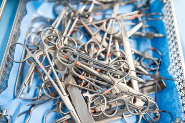  Hastane değerlendirmesi, sağlık hizmetleri veya tıbbi tiyatroda acil servis için ameliyathanede geçmiş, ameliyat ve metal aletler. Ameliyat için forseps ve makasla cerrahi ekipman.
