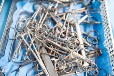  Hastane değerlendirmesi, sağlık hizmetleri veya tıbbi tiyatroda acil servis için ameliyathanede geçmiş, ameliyat ve metal aletler. Ameliyat için forseps ve makasla cerrahi ekipman.