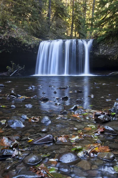 Vattenfall med nära håll av olika våta flodbädden stenar. — Stockfoto
