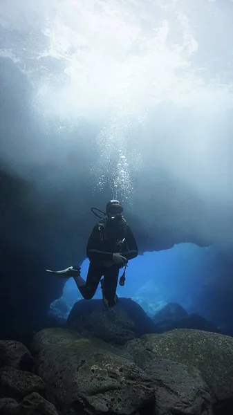 魔法の光を持つ洞窟の中のスキューバダイバーの水中写真 大西洋でのスキューバダイビングから — ストック写真