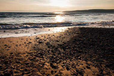 Tenby Wales UK 'de okyanusun üzerinde gün batımı. Yaz manzarası 