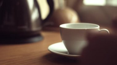 Kapatın. Bir fincana çay poşeti koy. Kaynar su dökün. Çay yap..