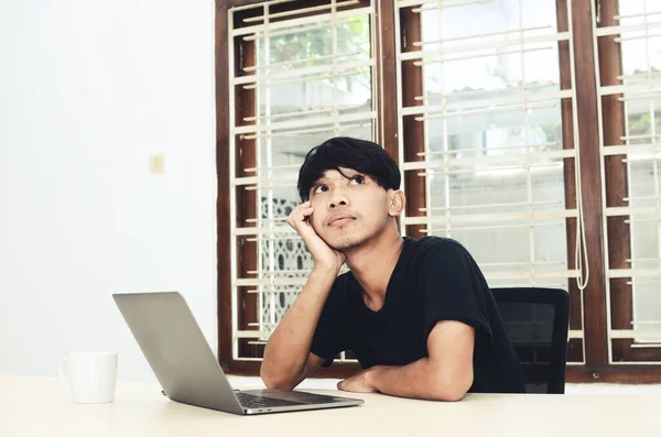 Een Aziatische Man Zit Voor Laptop Met Een Doordachte Uitdrukking — Stockfoto