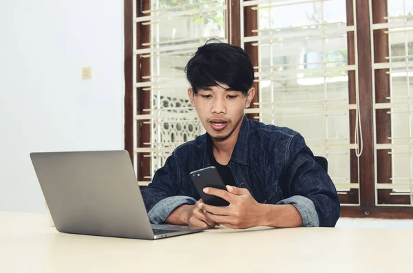 Asiático Está Sentado Frente Laptop Con Una Expresión Seria —  Fotos de Stock