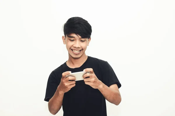 Egy Ázsiai Férfi Alkalmi Fekete Pólóban Játszik Telefonjával — Stock Fotó