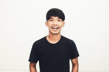 Sıradan siyah tişörtlü, gülümseyen yakışıklı Asyalı adam.