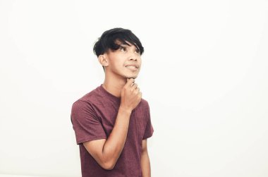 Asyalı adam düşünceli bir ifadeyle sıradan bir gömlekle gülümsedi.