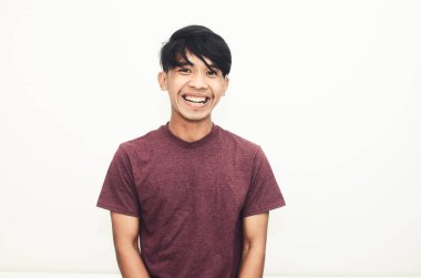 Sıradan tişörtler içinde gülümseyen yakışıklı Asyalı adam.