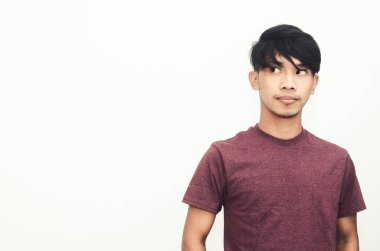 Asyalı adam düşünceli bir ifadeyle sıradan bir gömlekle gülümsedi.