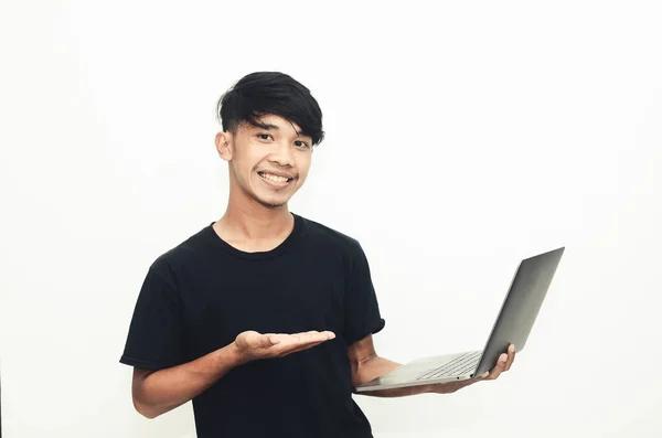 Sıradan Siyah Tişörtlü Asyalı Adam Dizüstü Bilgisayarı Işaret Ediyor — Stok fotoğraf