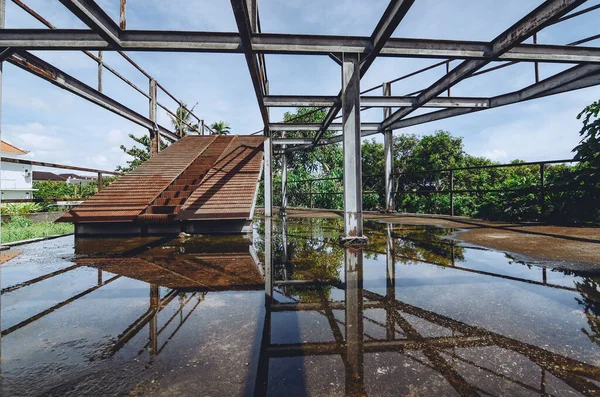 Su yansıması olan eski çelik yapı.