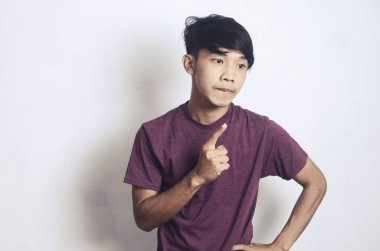 Beyaz bir arka planda kafası karışık ve düşünceli genç bir Asyalı.