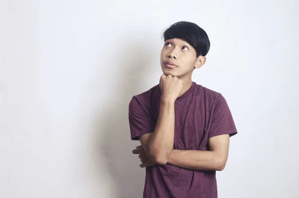 Beyaz Bir Arka Planda Kafası Karışık Düşünceli Genç Bir Asyalı — Stok fotoğraf
