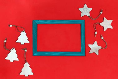 Tahta yıldızların olduğu bir Noel manzarası, kırmızı arka planda Noel ağaçları. Noel oyuncakları, yapılacaklar listesi, tebrik kartı. Metin için yeri olan Noel dekoru ve çerçevesi.