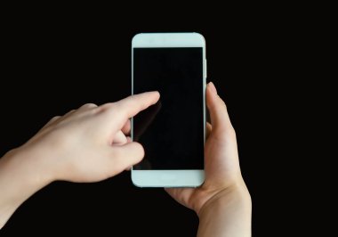 Kadının işaret parmağı siyah arkaplandaki boş bir cep telefonu ekranını gösteriyor. Parmağını cep telefonu ekranına yakın planda tut. Çevrimiçi iletişim için akıllı telefonu olan bir kadın.