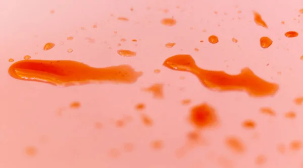 Su pembe dokuya damlıyor. Soyut sıvı renk arkaplanı. Makroyu birleştir. Kırmızı damlalı doğal arka plan. Düşük alan derinliği, seçici odak.