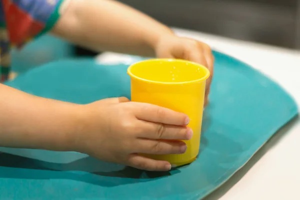 Руки Ребенка Муга Симпатичная Маленькая Девочка Держит Руках Пластиковую Желтую — стоковое фото
