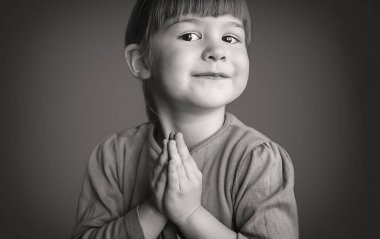 Komik şirin küçük kız dua ediyor, siyah beyaz, monokromlu fotokopi çekecek yeri olan. Sarışın, mutlu, gülümseyen küçük kız ellerini dua ve yakarış için kavuşturdu. Kavram, aşk, mutluluk