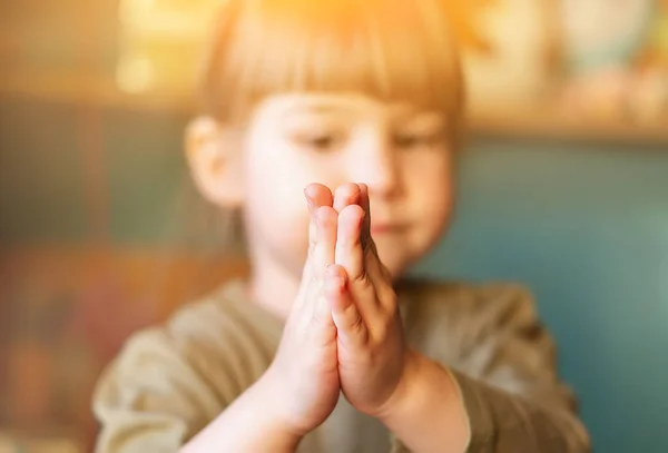 小さな子供が尋ねる 赤ん坊の女の子は祈りと祈願のために手を合わせて拍手した 家で祈っている面白いかわいい女の子 宗教の概念 ストックフォト