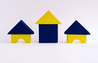 Beyaz arka planda çocukların yumuşak tasarımcılarından yapılmış renkli evler. Geometrik şekillerden yapılmış evler. Çocuklar için eğitici oyunlar. Bir aile için yeni bir ev kavramı. Konut inşaatı