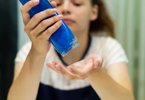 Mano Una Adolescente Vierte Limo Azul Una Botella Transparente Palma — Foto de Stock