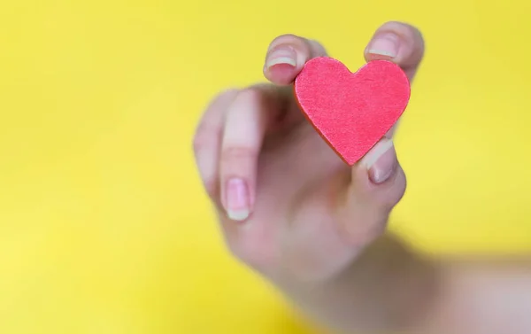 Eine Frauenhand Hält Ein Rotes Herz Auf Gelbem Hintergrund Selektiver Stockbild