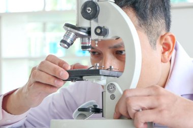 Asyalı bilim adamları veya kimyagerler mikroskop kullanıyorlar. Bilimsel deneyde Tıbbi farmasötik araştırma konsepti DNA yapısı, yenilik ve teknoloji
