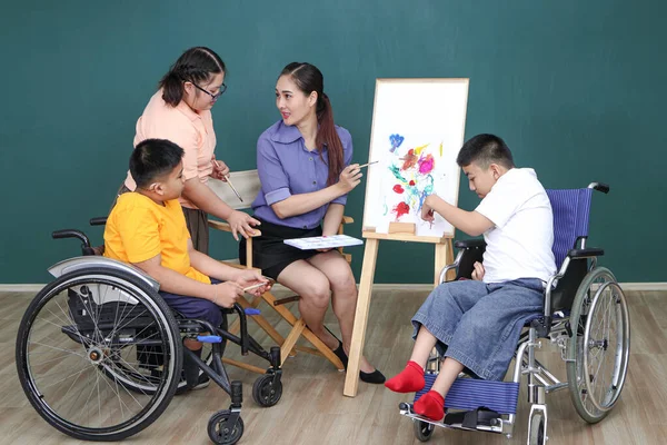 Children with Asian disabilities or autistic children are training their hand and finger muscles by painting with water. With the help of teachers Happily and concentrate in the classroom
