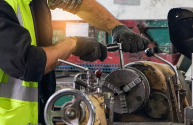 Torna kesme makinesi üzerinde çalışan profesyonel becerileri olan mühendisler. Konsept, işçiler makine parçaları üretiyorlar. Endüstriyel fabrikalarda metal damga makinelerinin bakımı için.