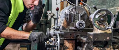 Torna kesme makinesi üzerinde çalışan profesyonel becerileri olan mühendisler. Konsept, işçiler makine parçaları üretiyorlar. Endüstriyel fabrikalarda metal damga makinelerinin bakımı için.