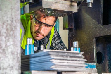 Profesyonel bir erkek mühendisin portresi güvenlik üniforması ve gözlük takıyor. Makinelerin bakımı ve kurulumu Endüstriyel fabrikalarda Metal parçaları üreten mühendislik işi kavramı